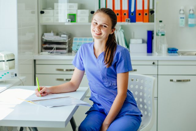 A young female medical assistant is at work in a medical office