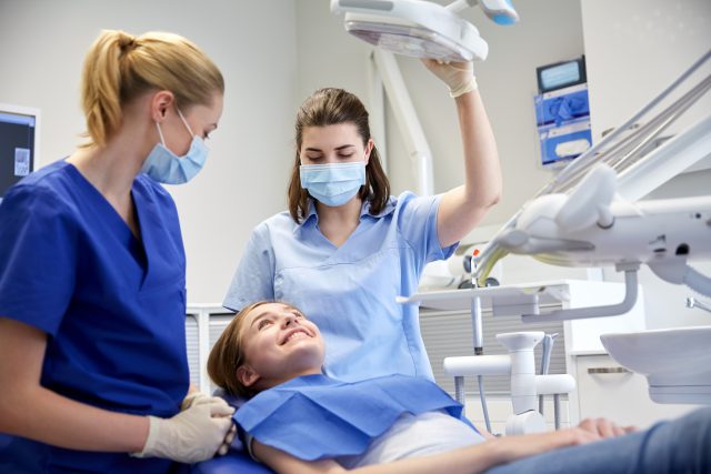 Dental assistant and dentist are with a patient